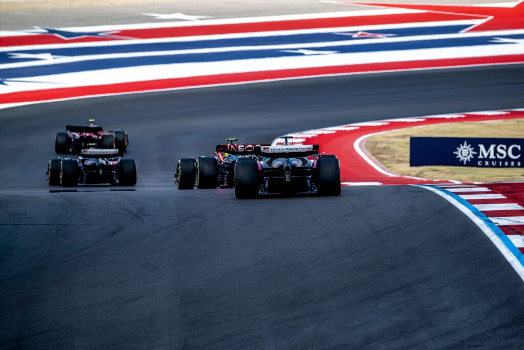 Formula 1 cars racing through a corner beside red, white and blue runoff areas in Austin.