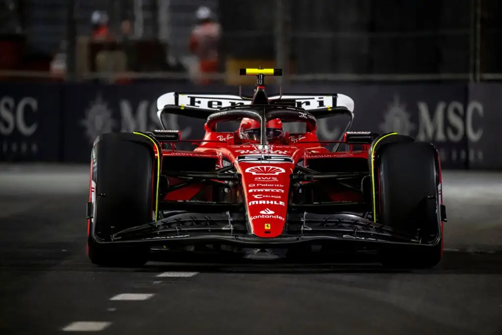 Front view of a Ferrari Formula 1 car racing under the lights in Las Vegas.