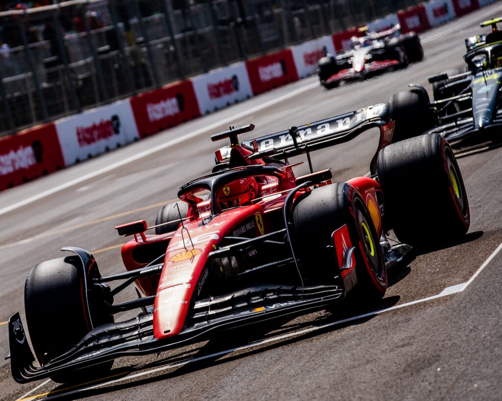 Ferrari Formula 1 car leading other cars through the Baku street circuit.