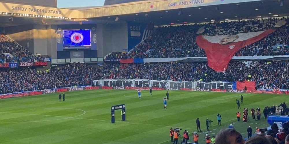 Packed stands at Ibrox Stadium with Rangers supporters cheering during a home match.