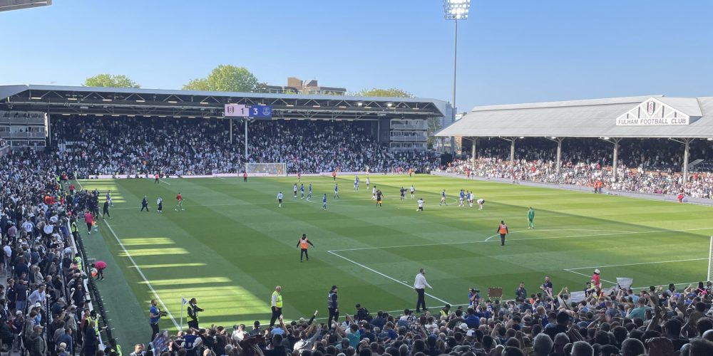 Packed stands at Craven Cottage with Fulham supporters cheering during a home match.